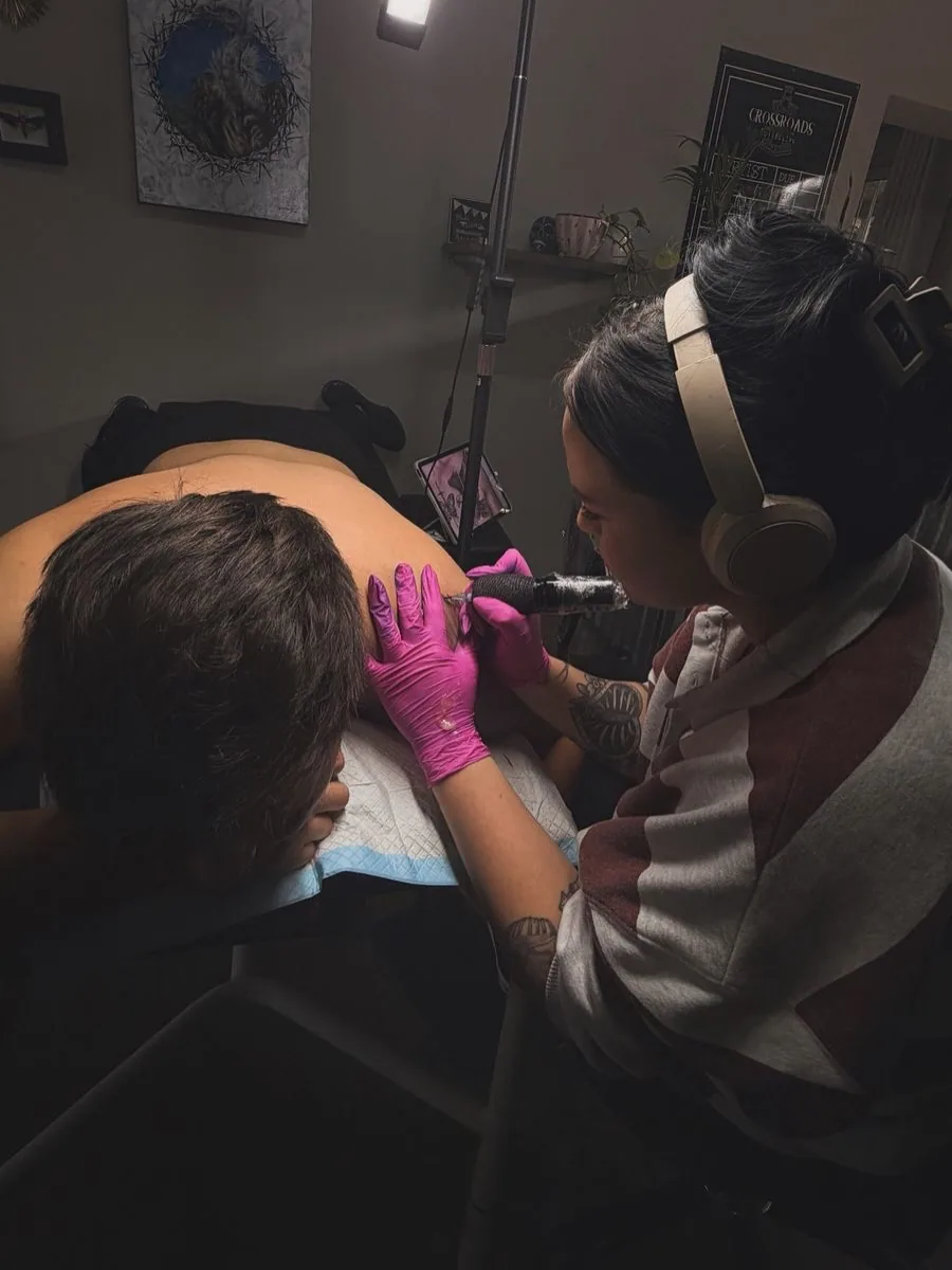 Kyla tattooing a client in the studio